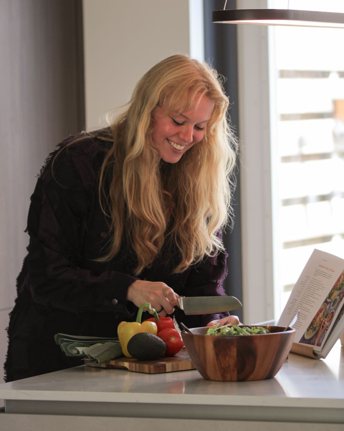 De coach snijdt lachend groenten voor een salade.